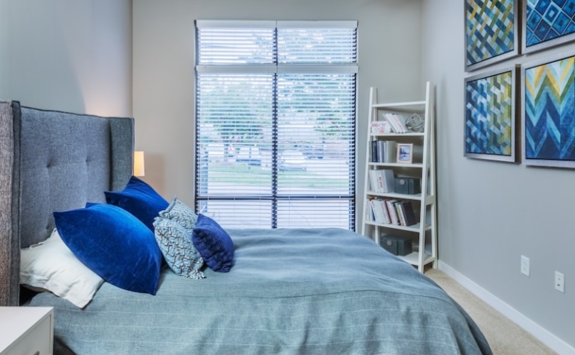 carpeted bedroom with picture window and ceiling fan